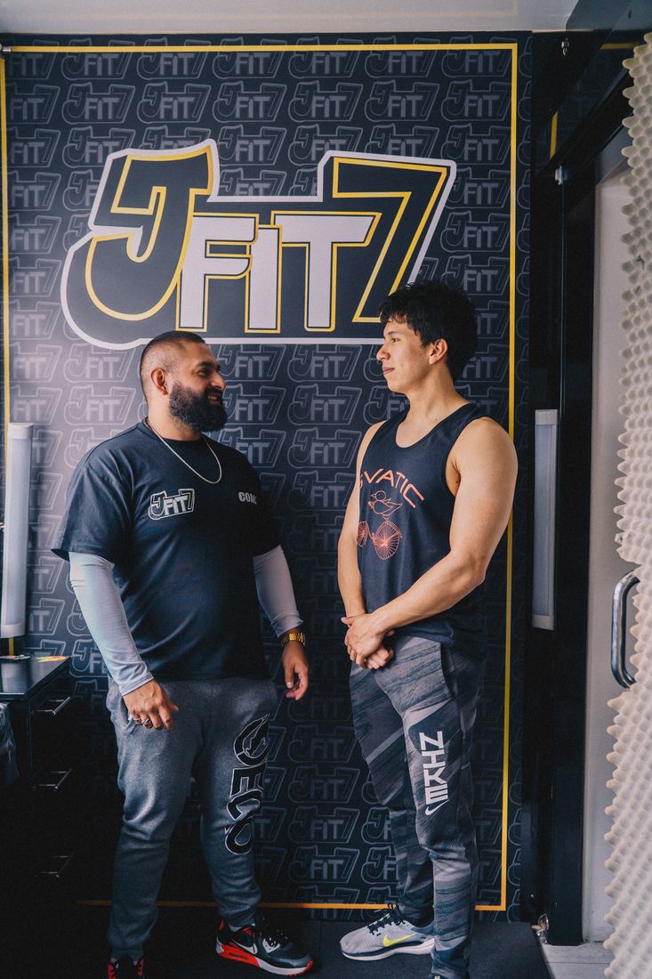 Josué con un cliente frente al muro JFIT7